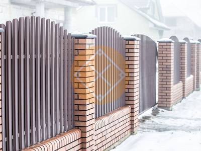 Забор из евроштакетника с кирпичными столбами и откатными воротами