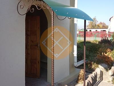 Козырек с коваными элементами и полуарочной крышей